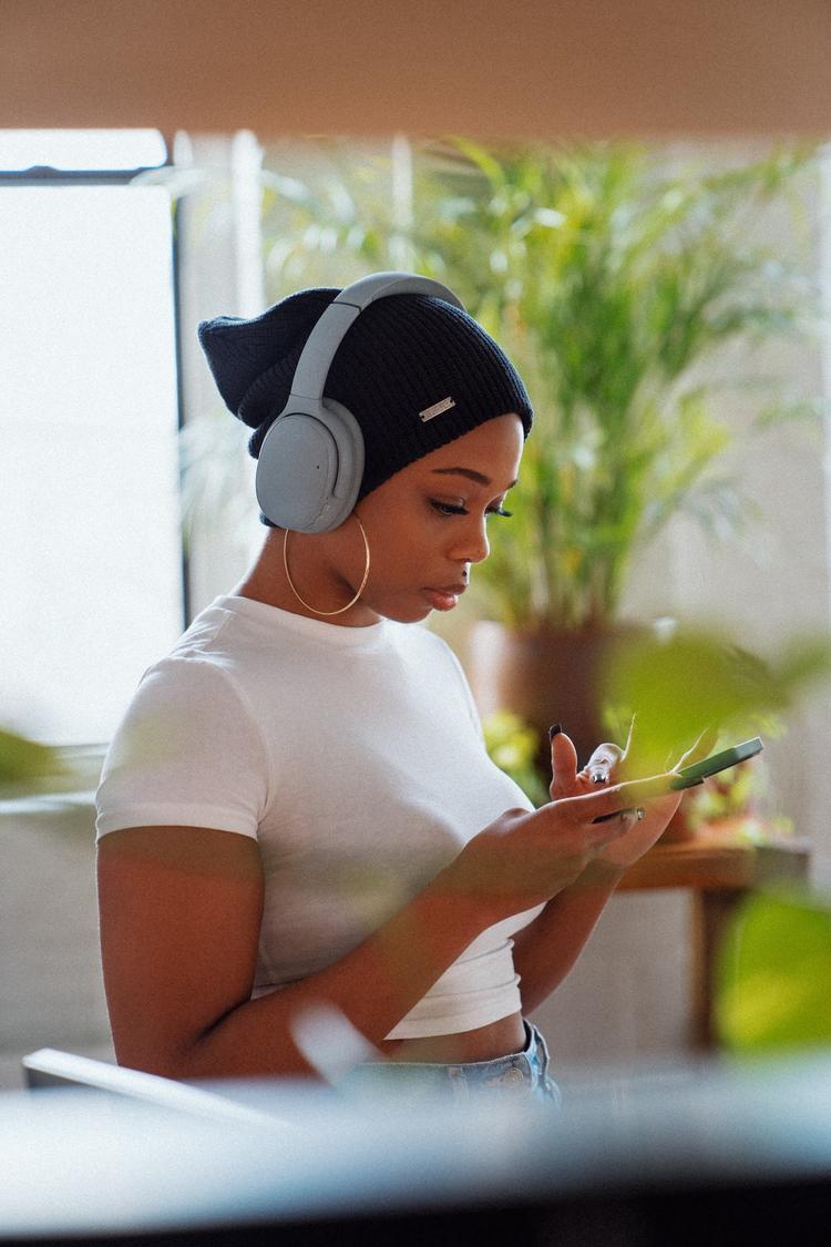 Girl in headphones listening to audio from her phone.